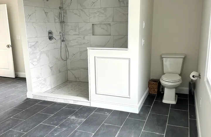 Marble tile shower over a slate tile floor