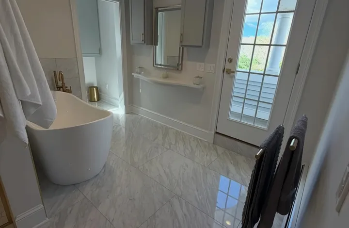 Remodeled bathroom with a tub, viewed from the hallway