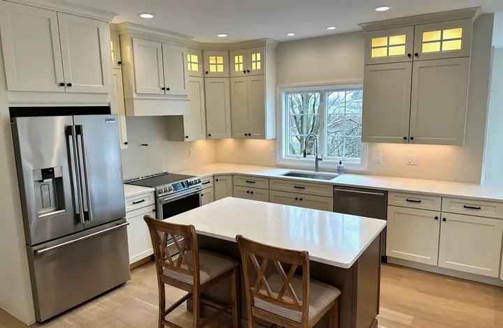 Finished kitchen remodel with cream shaker cabinets and a quartz-topped island, by River's Edge Home Center